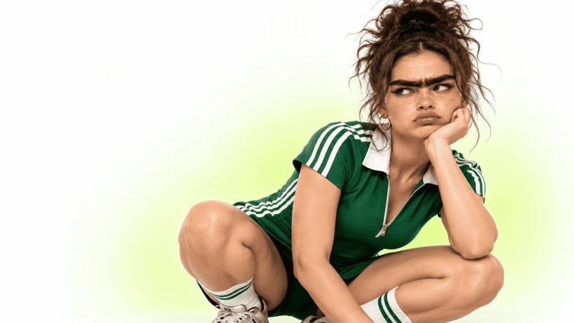 Personnage en tenue verte et sourcils exagérés, expression songeuse